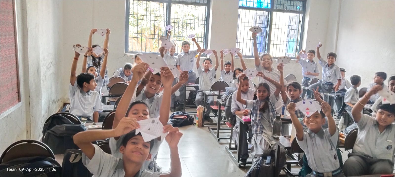 Students enthusiastically holding paper crafts